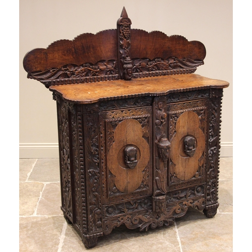 808 - A 19th century carved oak sideboard, probably Celtic, the cloud shaped rear gallery with a spire fin... 