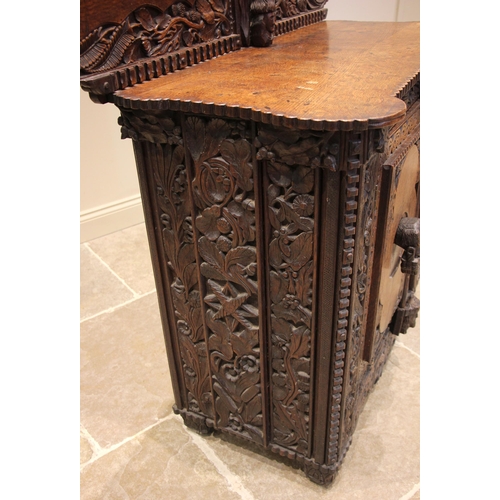 808 - A 19th century carved oak sideboard, probably Celtic, the cloud shaped rear gallery with a spire fin... 