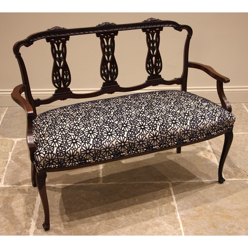 830 - An Edwardian mahogany two seater salon sofa, the three pierced and interlaced splats over a re-uphol... 