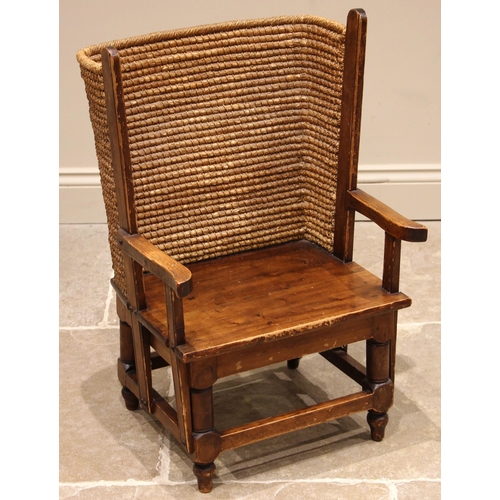 832 - A child's pine Orkney chair, mid 20th century, the curved woven rush back rest extending to outswept... 