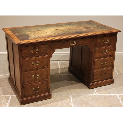 835 - An Edwardian oak kneehole writing desk, the moulded top inset with a green skiver (at fault), over a... 