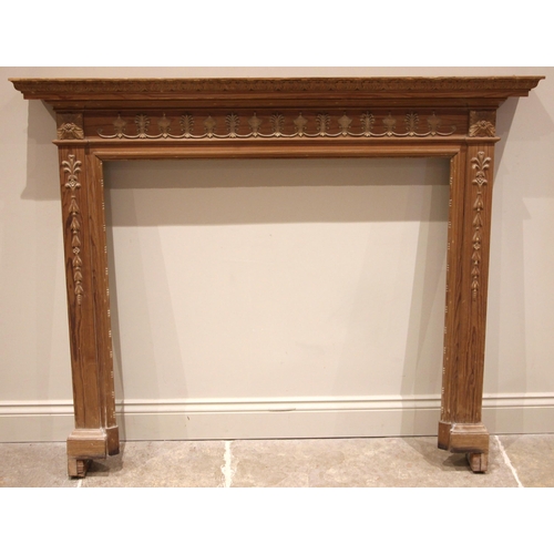 839 - An Adam style pine fire surround, early 20th century, the moulded pediment over a frieze applied wit... 