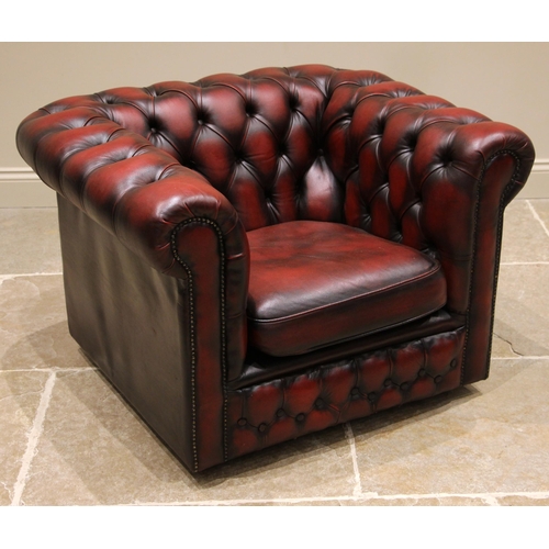 844 - An oxblood red leather Chesterfield sofa and conforming armchair, late 20th century, both of typical... 