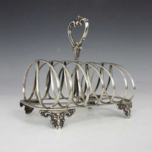 56 - A Victorian silver toast rack, John Evans II, London 1844, the cast openwork stylised handle above l... 