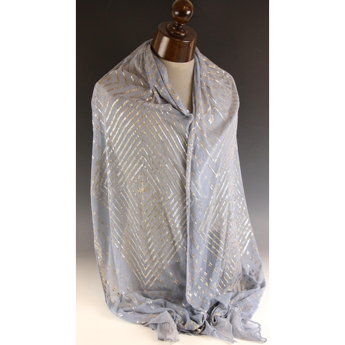 604 - An Egyptian Assuit shawl, 20th century, the blue lace ground extensively embellished with hammered s... 