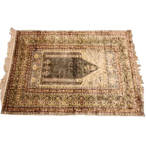 611 - A silkwork rug, late 19th/early 20th century, in ivory, green and brown colorways, the central field... 