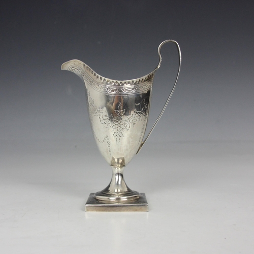 66 - A George III silver cream jug, Hester Bateman, London 1788, of helmet form with floral engraved garl... 