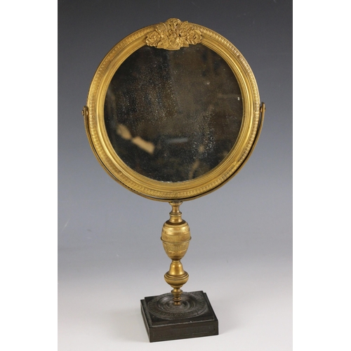 665 - An Empire ormolu shaving or dressing table mirror, early 19th century, the circular frame surmounted... 