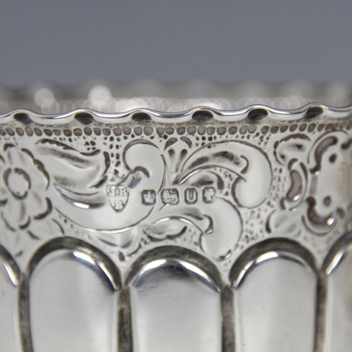 67 - A Victorian silver cream jug, Wakely & Wheeler, London 1885, the scroll handle above florally emboss... 