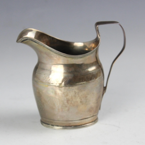 1 - A George III silver cream jug, indistinct makers mark, London 1800, of helmet form with engraved mon... 