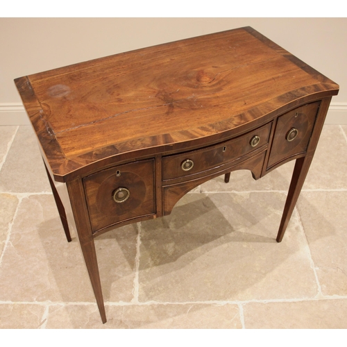 725 - A George III mahogany serpentine side table, the cross banded top over a central oak lined frieze dr... 