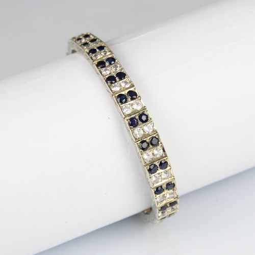 166 - An Art Deco style white and blue sapphire bracelet, the graduated white metal square panel set with ... 