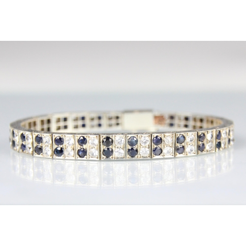 166 - An Art Deco style white and blue sapphire bracelet, the graduated white metal square panel set with ... 