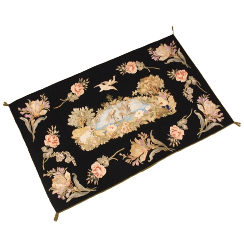 606 - A black felt and long stitch silk embroidered wall hanging, 19th century, possibly French, the centr... 