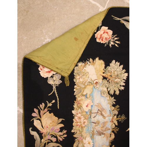 606 - A black felt and long stitch silk embroidered wall hanging, 19th century, possibly French, the centr... 