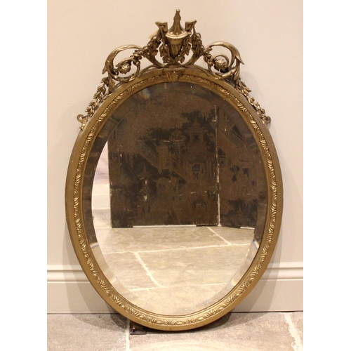 664 - A 19th century giltwood and gesso oval wall mirror, the urn, swag and scroll crest extending to the ... 