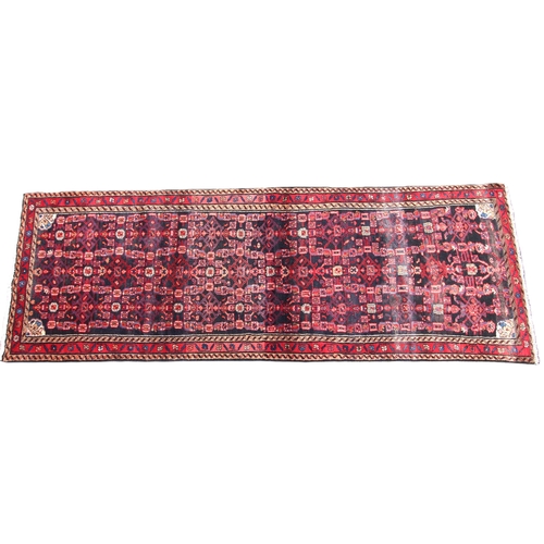 671 - A full pile deep rich ground Persian runner, the all over geometric design within a continual border... 