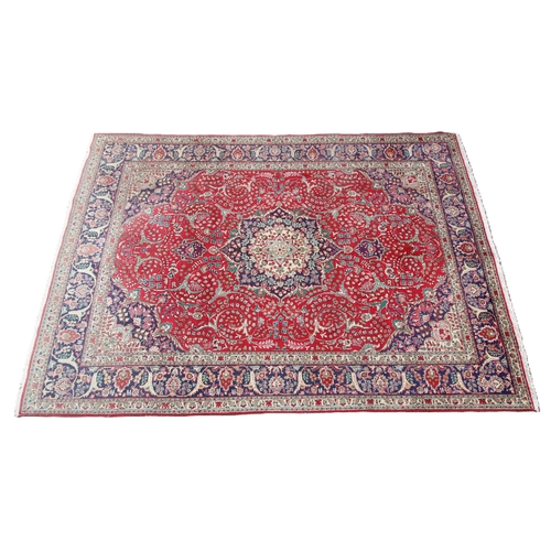 672 - A fine woven red ground Persian Kashan carpet, the traditional lozenge medallion design with conform... 