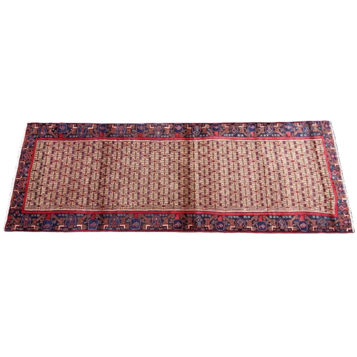 673 - A deep ground full pile Persian Navan runner, the central field with an all over design, in red, blu... 