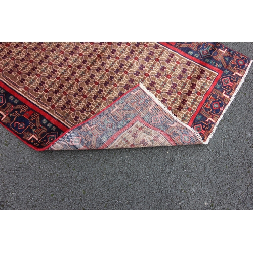 673 - A deep ground full pile Persian Navan runner, the central field with an all over design, in red, blu... 