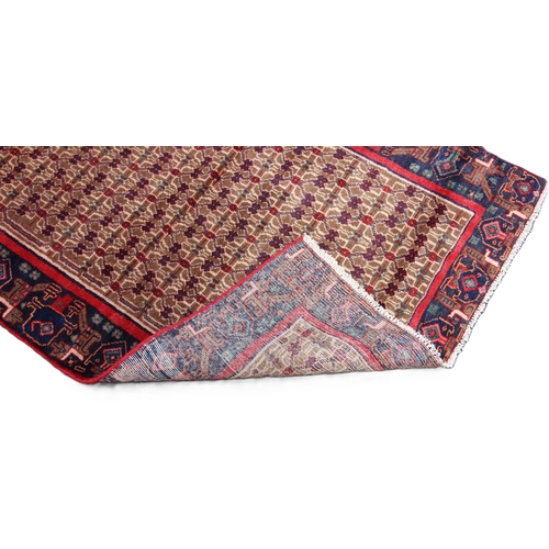 673 - A deep ground full pile Persian Navan runner, the central field with an all over design, in red, blu... 