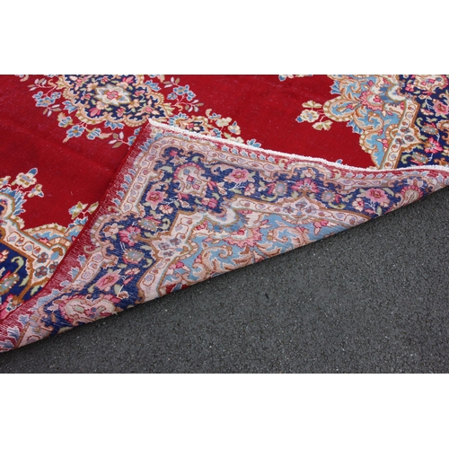 674 - A rich red ground Persian Kashmar carpet, the central floral medallion upon a vibrant red ground, em... 