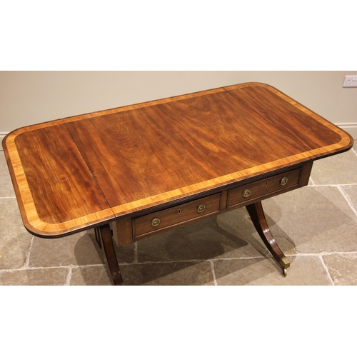 764 - A George IV mahogany and tulip wood crossbanded sofa table, the drop leaf top over a pair of cock be... 