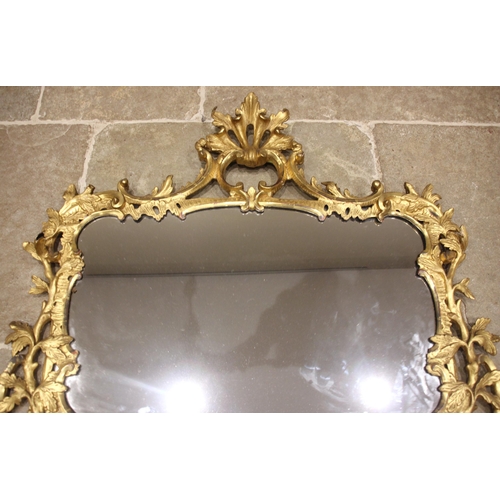 663 - A French giltwood and gesso rococo wall mirror, 19th century, the 'C' scroll openwork leafy crest ex... 