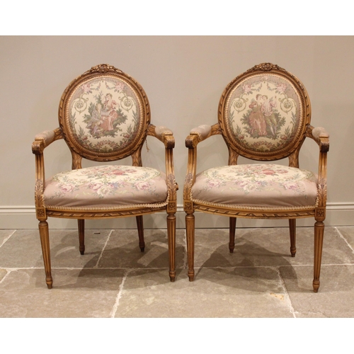 833 - A pair of carved beech fauteuil a la reine elbow chairs, mid 20th century, each with a tapestry padd... 