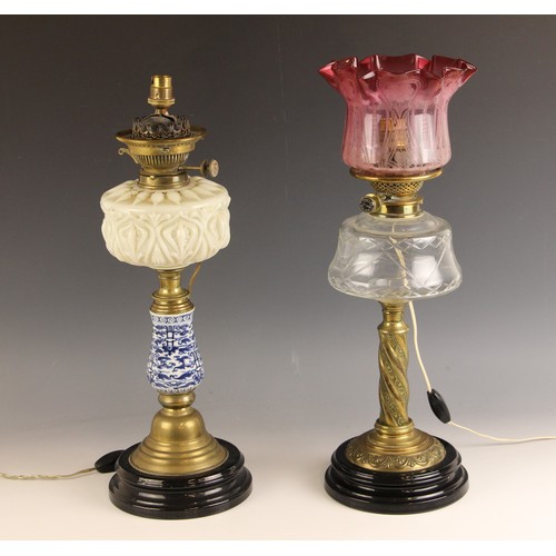 651 - A Victorian brass Hinks Duplex oil lamp, with a relief moulded milk glass reservoir upon blue and wh... 