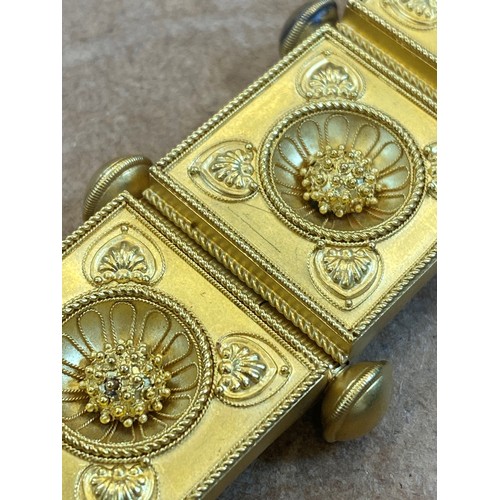 265 - A 19th century Etruscan Revival yellow metal bracelet, the seven square shaped panels with central s... 