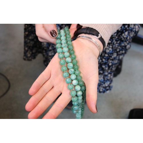 291 - A string of hydrogrossular garnet beads, the ‘jade’ coloured beads with screw barrel fastening, 76cm... 