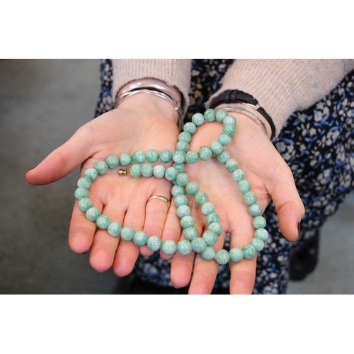 291 - A string of hydrogrossular garnet beads, the ‘jade’ coloured beads with screw barrel fastening, 76cm... 