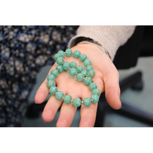 291 - A string of hydrogrossular garnet beads, the ‘jade’ coloured beads with screw barrel fastening, 76cm... 