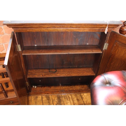 733 - A George III and later constructed oak wall cabinet, the moulded cornice over a pair of panelled doo... 