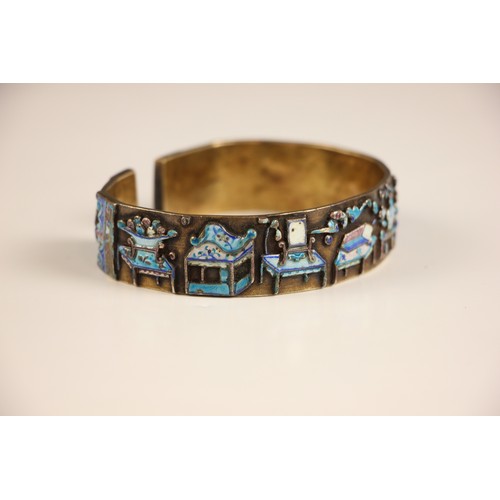 320 - A Chinese enamel and gilt metal bangle, the wide cuff style bangle decorated in naively enamelled sy... 