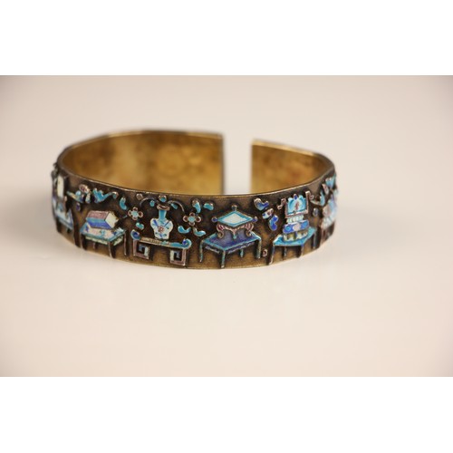 320 - A Chinese enamel and gilt metal bangle, the wide cuff style bangle decorated in naively enamelled sy... 