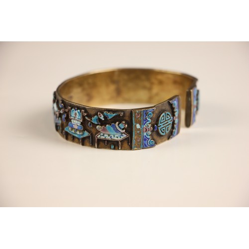 320 - A Chinese enamel and gilt metal bangle, the wide cuff style bangle decorated in naively enamelled sy... 