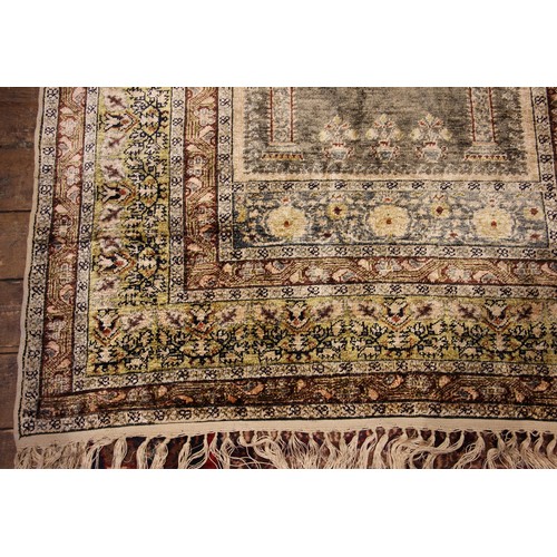 611 - A silkwork rug, late 19th/early 20th century, in ivory, green and brown colorways, the central field... 