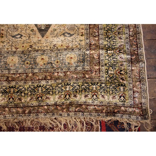 611 - A silkwork rug, late 19th/early 20th century, in ivory, green and brown colorways, the central field... 