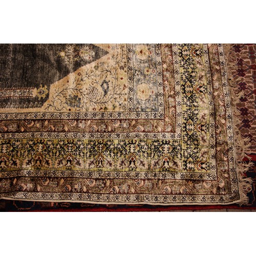 611 - A silkwork rug, late 19th/early 20th century, in ivory, green and brown colorways, the central field... 