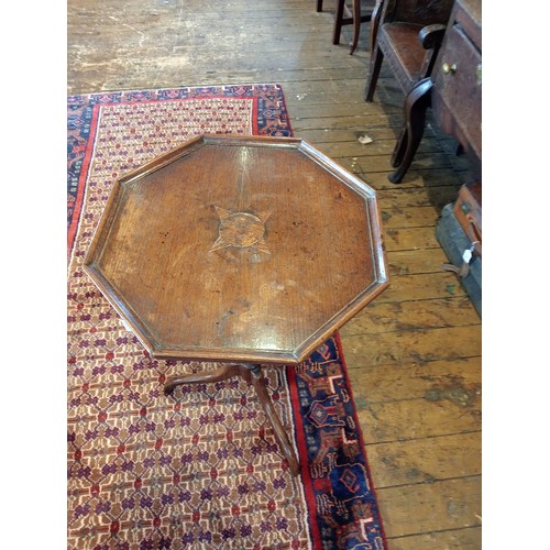 740 - A George III oak tripod table, the octagonal top with a moulded rim upon a slender baluster column a... 