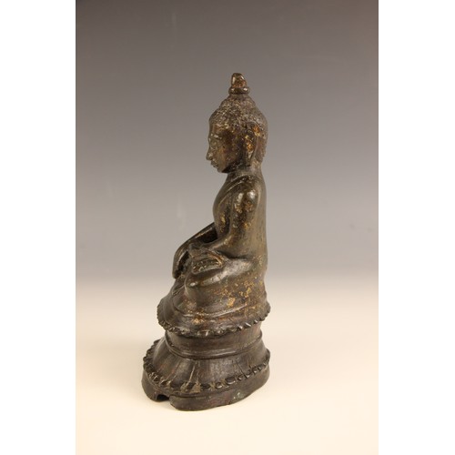 602 - A South-East Asian bronze model of a seated buddha, Nepal, 18th century, seated in dhyanasana with h... 