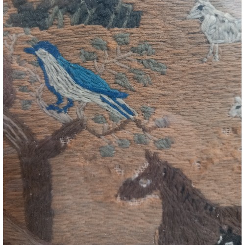 612 - A wool embroidered needlework picture or sampler, 19th century, depicting a village scene with birds... 