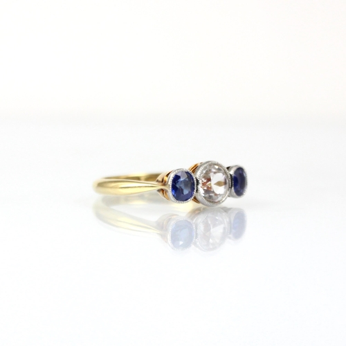 195 - An early 20th century diamond and sapphire three stone ring, the central old cut diamond with small ... 