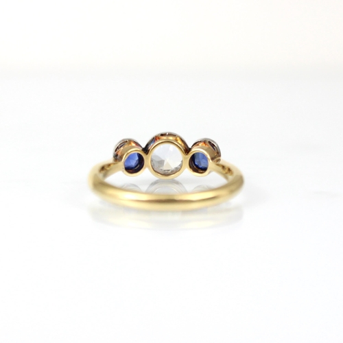 195 - An early 20th century diamond and sapphire three stone ring, the central old cut diamond with small ... 