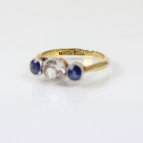 195 - An early 20th century diamond and sapphire three stone ring, the central old cut diamond with small ... 