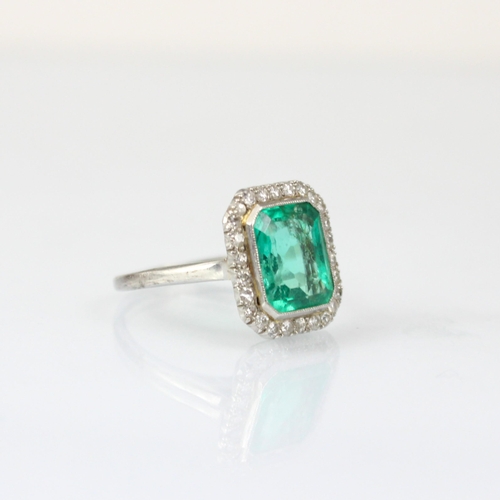 255 - An early 20th century untested emerald and diamond cluster ring, the central emerald cut emerald wit... 