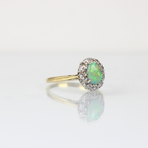 294 - An early 20th century opal and diamond cluster ring, the oval cabochon opal within a surround of mix... 