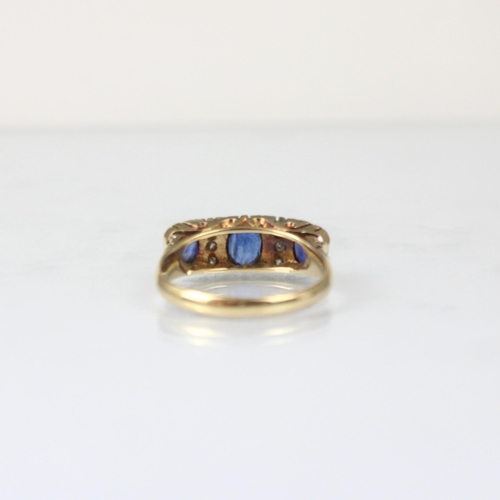 330 - A Victorian style diamond and synthetic sapphire ring, the three graduated oval cut sapphires with d... 